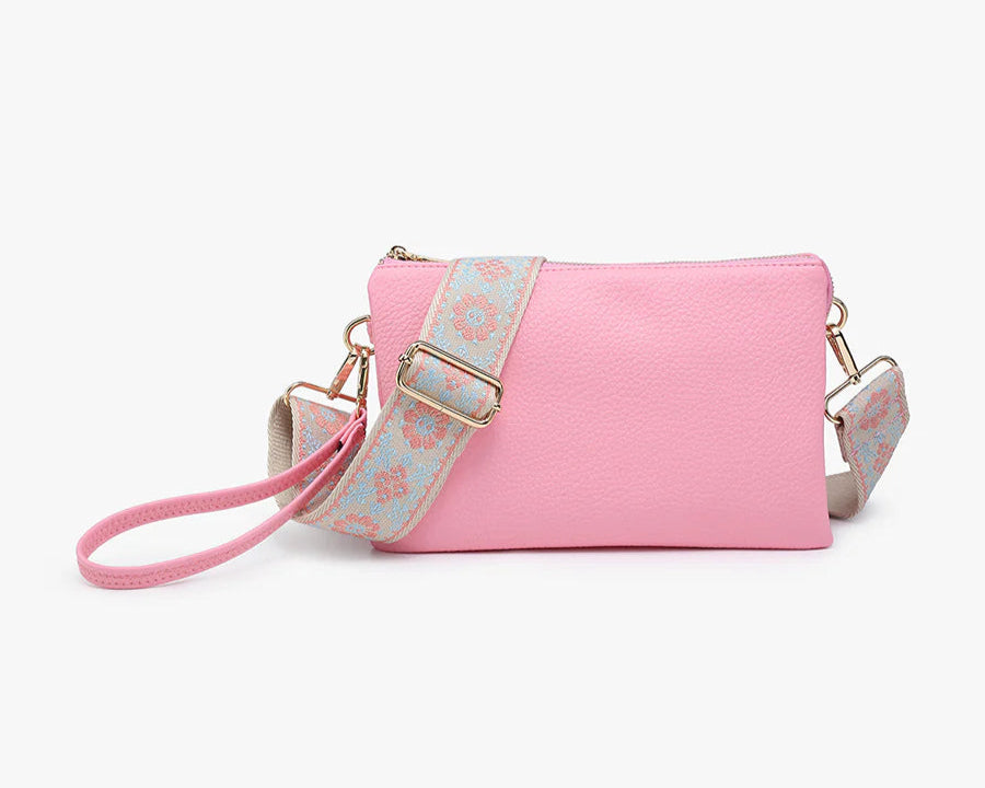 Pink handbag with a floral strap on a white background